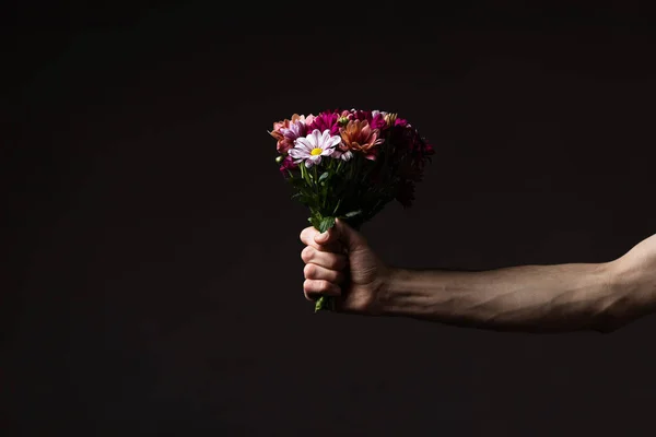 Καλλιεργημένη Άποψη Του Ανθρώπου Που Κρατά Λουλούδια Μπουκέτο Απομονώνονται Μαύρο — Φωτογραφία Αρχείου