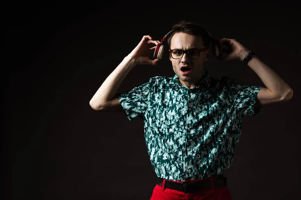 Sorprendido Hombre Moda Gafas Escuchando Música Auriculares Aislados Negro — Foto de Stock