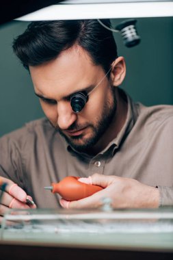 Havalandırma ile çalışan yakışıklı saatçinin seçici odak noktası