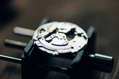 Close up view of open mechanical wristwatch on movement holder  clipart