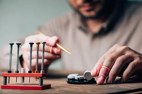 Cropped View Watchmaker Holding Tweezers Tool Tray Screwdrivers Table — Stock Photo, Image