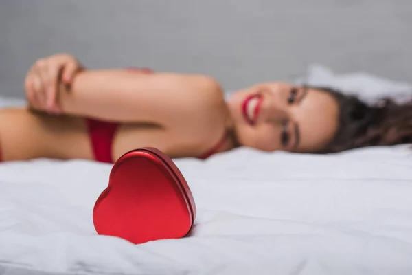 Kalp Şeklinde Hediye Kutusunun Seçici Odağı Yatakta Yatan Seksi Gülümseyen — Stok fotoğraf