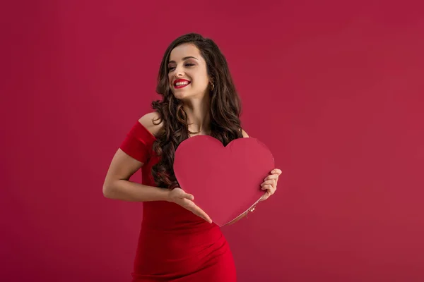 Sensueel Elegant Meisje Met Papieren Hart Terwijl Glimlachen Geïsoleerd Rood — Stockfoto