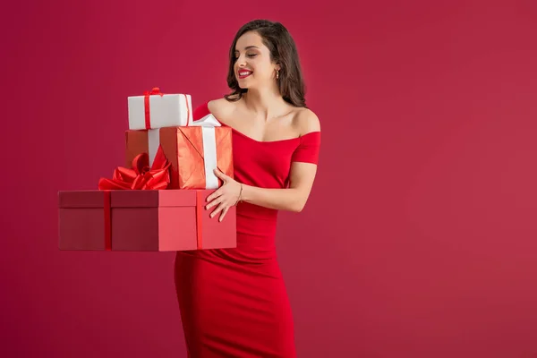 Sexy Elegant Girl Holding Gift Boxes While Smiling Isolated Red — ストック写真