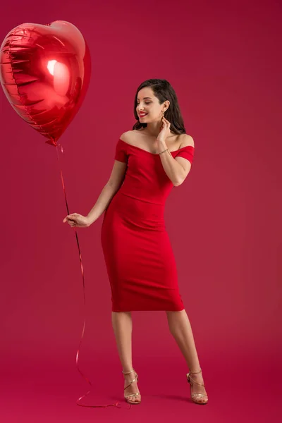 Sorrindo Menina Elegante Segurando Balão Forma Coração Tocar Pescoço Fundo — Fotografia de Stock