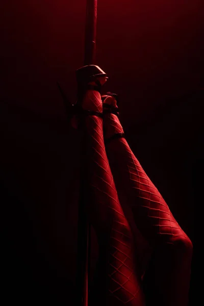 Обрезанный Вид Стриптизерши Каблуках Возле Пилона Черном Красным Освещением — стоковое фото