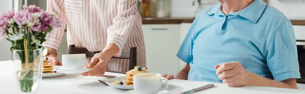 Vista Recortada Mujer Poniendo Café Panqueques Mesa Por Marido Plano — Foto de Stock