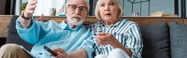 Panoramic Shot Senior Man Pointing Hand Shocked Wife While Watching — 스톡 사진