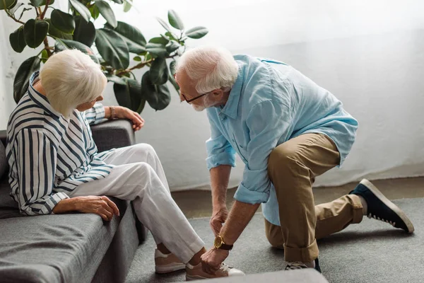 Seitenansicht Eines Älteren Mannes Der Schuh Seiner Frau Wohnzimmer Schnürt — Stockfoto