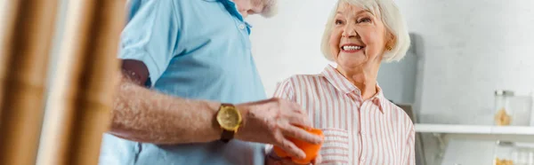 Foto Panorámica Una Mujer Sonriente Mirando Marido Con Pimiento Cocina — Foto de Stock