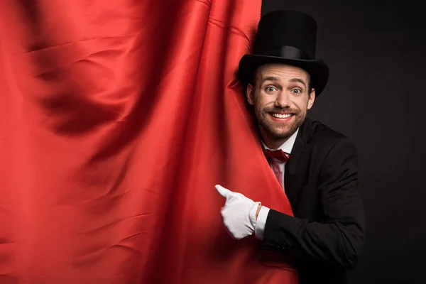身穿西服 头戴帽子 面带微笑的魔术师 带着红色窗帘在马戏团里大显身手 — 图库照片