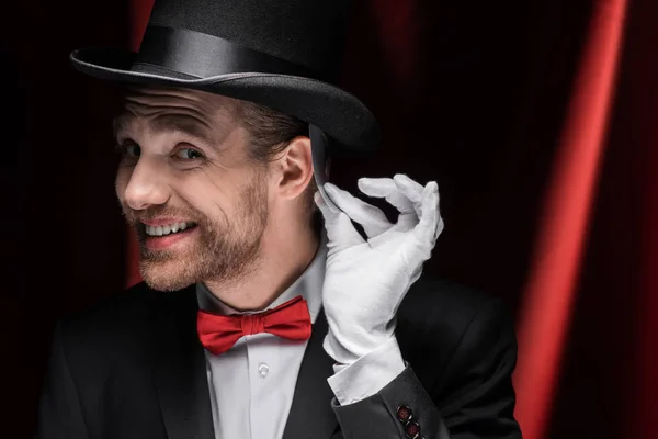 Smiling Magician Holding Playing Card Circus Red Curtains — Stock Photo, Image