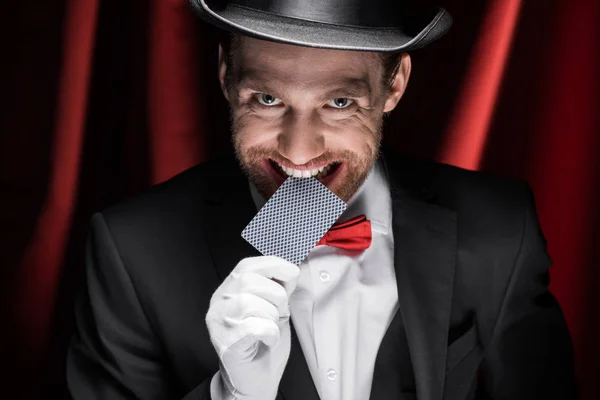 Leende Trollkarl Hålla Spelkort Tänder Cirkus Med Röda Gardiner — Stockfoto