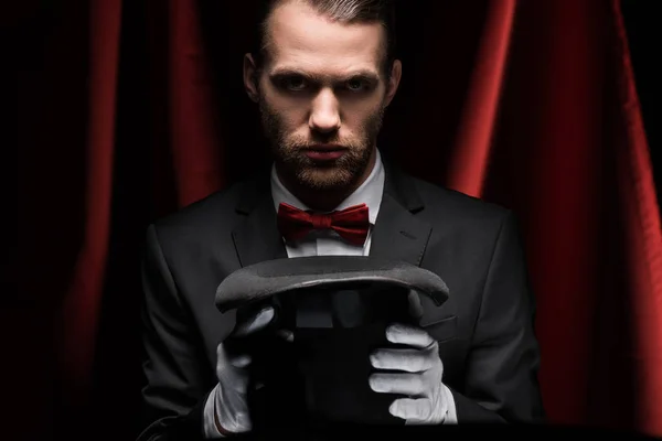 Concentrated Magician Suit Holding Hat Circus Red Curtains — 스톡 사진