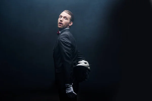 Surprised Magician Holding White Rabbit Hat Dark Room Smoke — Stock Photo, Image