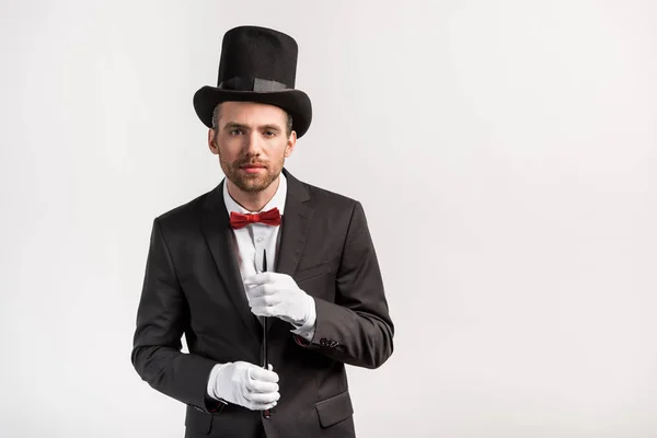 穿着西服头戴帽子的英俊魔术师 手持魔杖 与灰色隔离 — 图库照片