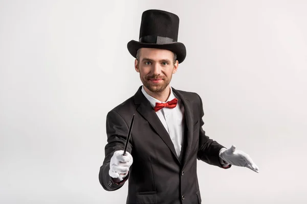 身穿西服头戴帽子的魔术师 手持魔杖 与灰色隔离 — 图库照片
