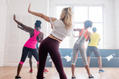 Rückansicht multiethnischer Zumba-Tänzer, die Bewegungen im Tanzstudio ausführen