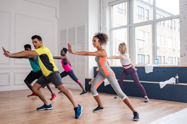 Çok kültürlü dansçılar dans stüdyosunda zumba eğitiyorlar. 