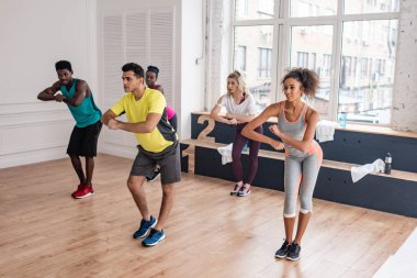 Çok kültürlü zumba dansçıları dans stüdyosunda birlikte antrenman yapıyorlar. 