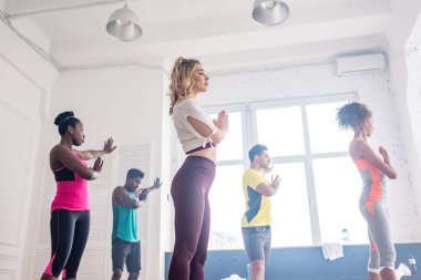 Dans stüdyosunda zumba hareketleri yapan çok kültürlü dansçıların düşük açılı görüntüsü