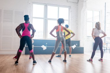 Çok ırklı zumba dansçılarının dans stüdyosunda birlikte antrenman yapmaları.