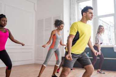 Dans stüdyosunda birlikte zumba yapan genç dansçılar.