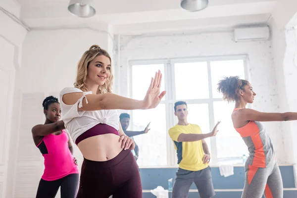 Hermosa Entrenadora Sonriendo Mientras Realiza Zumba Con Bailarines Multiculturales Estudio —  Fotos de Stock