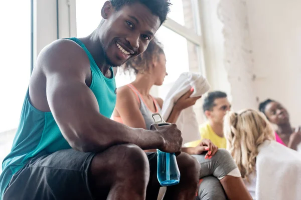 Selective Focus African American Dancer Holding Sports Bottle While Smiling — 스톡 사진