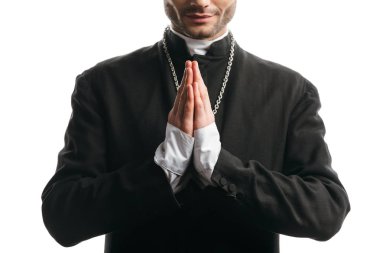 cropped view of catholic priest in black cassock praying isolated on white
