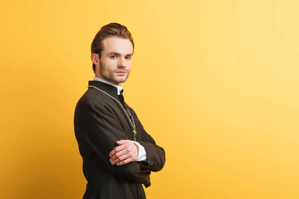 Confident Catholic Priest Crossed Arms Looking Camera Isolated Yellow — 스톡 사진