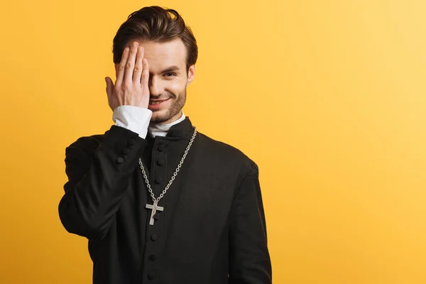 Smiling Catholic Priest Covering Eye Hand While Looking Camera Isolated — 스톡 사진