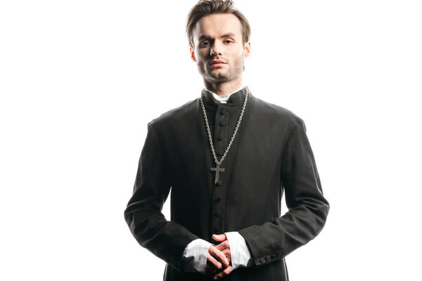 young, confident catholic priest looking at camera isolated on white