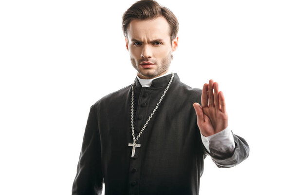 serious, strict catholic priest showing stop gesture at camera isolated on white