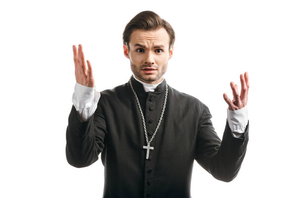 discouraged catholic priest showing shrug gesture while looking at camera isolated on white
