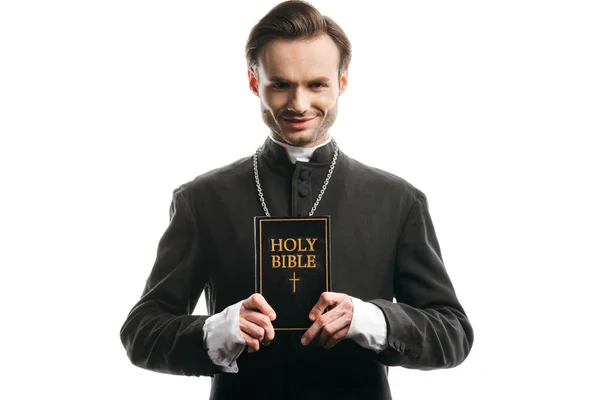 Молодой Улыбающийся Католический Священник Показывает Священную Библию Изолированную Белом — стоковое фото