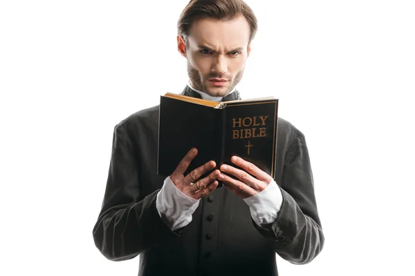 Frowning Catholic Priest Looking Camera While Holding Holy Bible Isolated — Stock Photo, Image