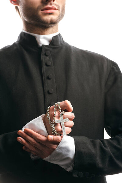 обрезанный вид молодого католического священника с ожерельем с серебряным крестом, изолированным на белом
