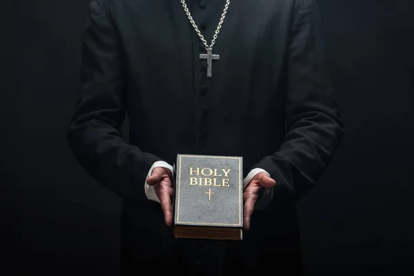 Vista Cortada Padre Católico Segurando Bíblia Sagrada Isolado Preto — Fotografia de Stock