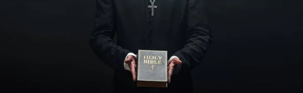Cropped View Catholic Priest Holding Holy Bible Isolated Black Panoramic — Stock Photo, Image