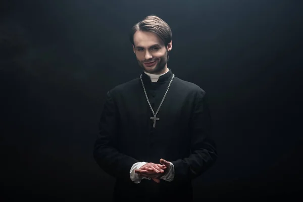 Young Smiling Catholic Priest Standing Folded Hands Looking Camera Isolated — Stock Photo, Image