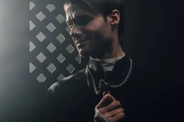 Young Worried Catholic Priest Touching Cross His Necklace Dark Confessional — Stock Photo, Image