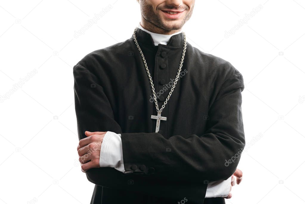 cropped view of smiling catholic priest standing with crossed arms isolated on white