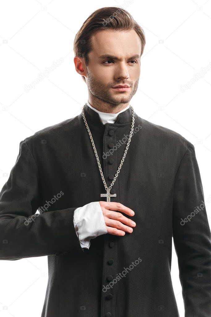 young, confident catholic priest in black cassock looking away isolated on white