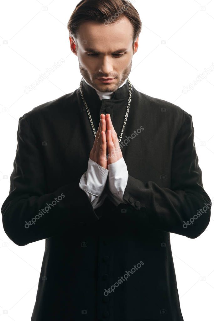 serious catholic priest praying with bowed head isolated on white