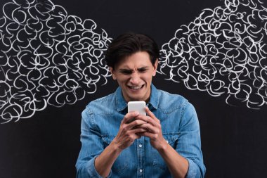 stressed young man using smartphone, with steam from ears drawing on blackboard