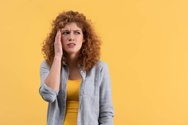 beautiful stressed girl having headache isolated on yellow