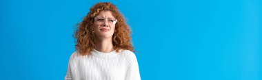panoramic shot of beautiful redhead upset girl crying isolated on blue
