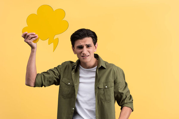 stressed man holding cloud speech bubble, isolated on yellow