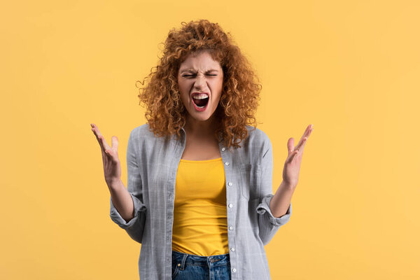 aggressive shouting redhead girl, isolated on yellow